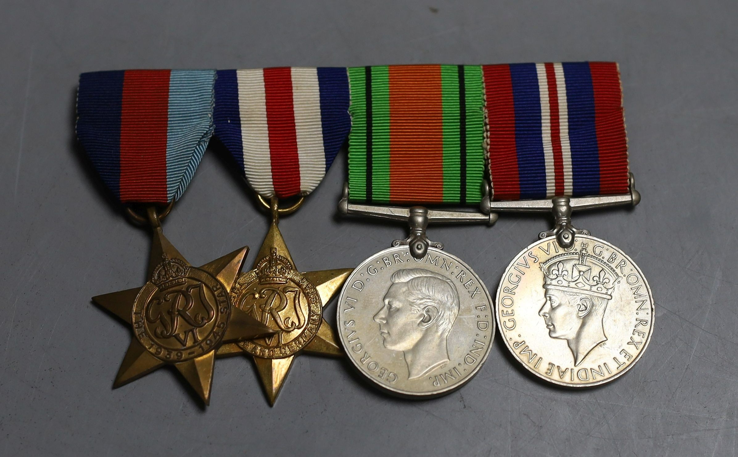 A group of five WW2 medals, together with a selection of cap badges and a GS Mk.II pocket watch